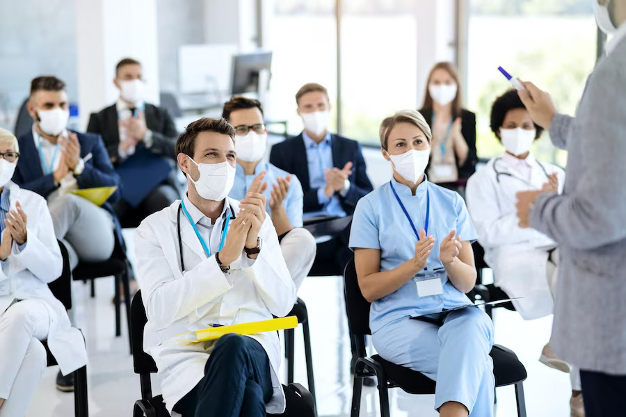 healthcare-workers-business-people-wearing-face-masks-applauding-seminar_637285-9140